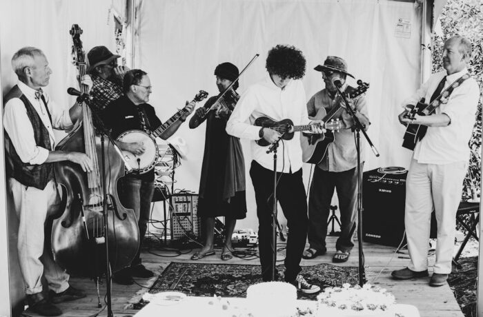Musicians performing a ceilidh-style folk set on a small stage